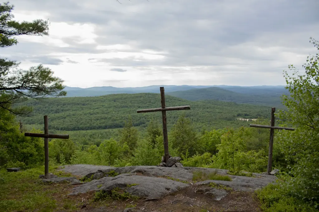Three wooden crosses standing on a hilltop at His Mansion