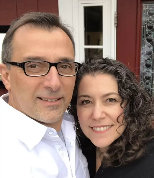 Armand and Madeline Paladino outside a red clapboard building at His Mansion