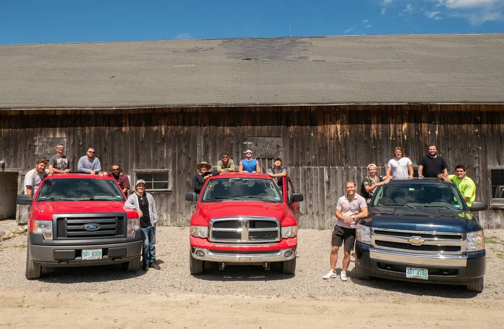 two red trucks one blue truck with men standing around them
